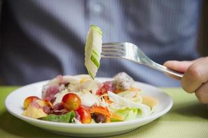 Mann essfertiger Gemüsesalat - Menschen mit sauberem, frischem, gesundem Lebensmittelkonzept foto