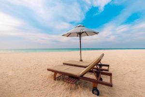 wunderschöner Strand. Stühle am Sandstrand in der Nähe des Meeres. sommerferien- und urlaubskonzept für den tourismus. inspirierende tropische Landschaft foto