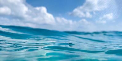 abstrakter Meerblick. blaue meer- oder ozeanwasseroberfläche und unterwasser mit sonnigem und bewölktem himmel foto