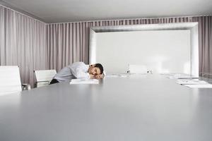 Geschäftsmann, der im Konferenzraum schläft foto