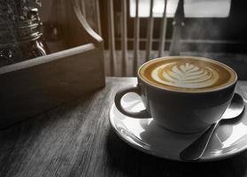 heiße Kaffeetasse mit warmem Morgenlichtfenster, Schwarz-Weiß-Ton mit partiellem Farbschichtbild foto