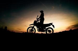 Herren-Silhouetten und Touren-Motocross-Bikes. Park zum Entspannen in den Bergen am Abend. abenteuerreise- und freizeitkonzept foto