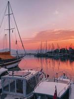 schiffe im ozean auf dem pier fabelhafter rosa sonnenuntergang foto