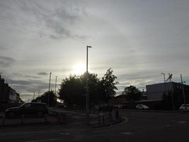 schöner sonnenuntergang über der britischen stadt, bunter himmel mit gelben, orangefarbenen und schwarzen wolken über hellblauem himmel foto