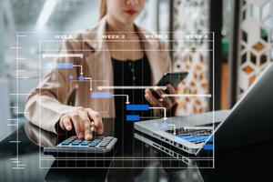 Arbeits- und Aktualisierungsaufgaben des Projektmanagers mit Meilenstein-Fortschrittsplanung und Gantt-Diagramm-Planungsdiagramm. geschäft, das mit smartphone, tablet und laptop im büro arbeitet. foto