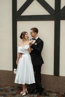 junges Paar Braut und Bräutigam in einem weißen kurzen Kleid foto