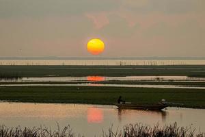 der große sonnenaufgang ist orange. Sonnenaufgang über dem Meer und Mangrovenwald foto