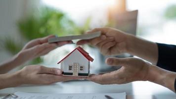Eine professionelle Immobilienmaklerin erhält von ihrem Kunden eine Zahlung für ein Hausdarlehen oder eine Mietgebühr. Immobilieninvestitionskonzept. beschnittenes Bild foto