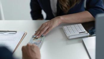 nahaufnahme der geschäftsmannhand, die seinem partner auf dem tisch geld, bargelddollarbanknoten gibt - kredit-, bestechungs- und korruptionskonzepte foto