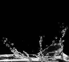 Spritzwasser isoliert auf schwarzem Hintergrund foto