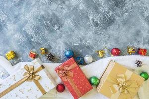 Draufsicht auf Geschenkboxen mit Weihnachtsdekoration auf grauem Grunge-Hintergrund. foto