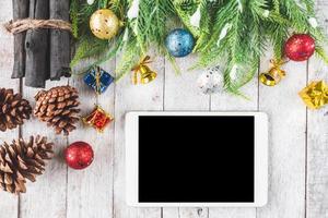 Draufsicht des Tablets mit Weihnachtsdekoration auf Holztischhintergrund foto