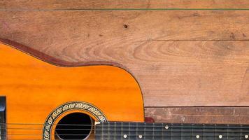 Draufsicht-Arbeitsbereich mit akustischer Gitarre auf Holztischhintergrund. foto