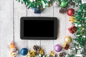 Draufsicht des Tablets mit Weihnachtsdekoration auf weißem Holztischhintergrund foto