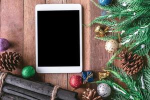 Draufsicht des Tablets mit Weihnachtsdekoration auf Holztischhintergrund foto