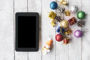 Draufsicht des Tablets mit Weihnachtsdekoration auf weißem Holztischhintergrund foto
