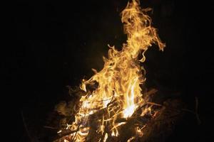 Lagerfeuer im Dunkeln. Flammen in der Nacht. brennendes Holz. Campingdetails. foto