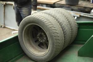 Räder des Autos. Austausch von Winterreifen beim Transport. alte Reifen sind im Anhänger gestapelt. foto