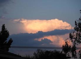 Wolkengebilde bei Sonnenuntergang auf dem See foto