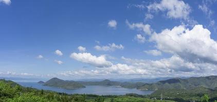 klarer blauer himmel weiße wolken, bäume, natürliche grasbäume rund um den srinakarin-stausee, kanchanaburi, thailand foto