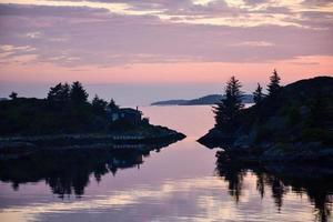 Sonnenuntergang über dem norwegischen Fischerdorf bis zum 10. Sommer foto