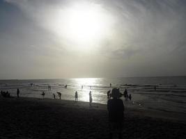 Silhouettenmenschen am Strand foto