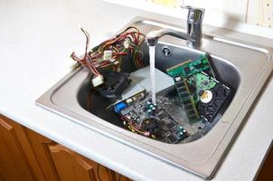 personal computer-reinigungskonzept. Hardware in der Küchenspüle foto