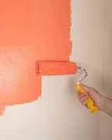 malerei der wand mit orangefarbener farbe nahaufnahme, kosmetische reparaturen im haus foto