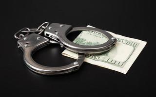 Betrug und Geldwäschekriminalität, Handschellen und Dollar foto