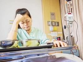 Eine Patientin ist langweiliges Essen in einem Krankenhaus foto