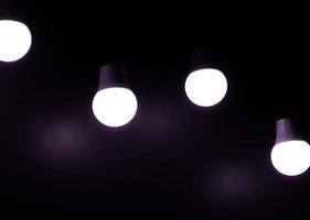 offene glühbirne auf schwarzem hintergrund. lila farbe hinzufügen foto