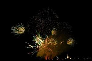 riesiges, buntes Feuerwerk über den Reisfeldern in der Abenddämmerung. foto