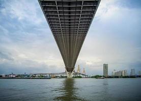 die Brücke über den Fluss an einem bewölkten Tag am Himmel. Bhumibol-Brücke, Samut Prakan, Thailand foto