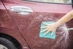 mann wäscht auto mit shampoo - alltagsautopflegekonzept foto