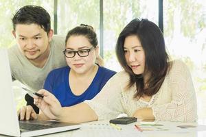 Zwei Frauen und ein Mann arbeiten im modernen Büro am Computer foto