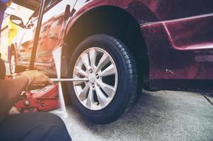 autoreifen zur wartung in der garage mit hydraulikheber gewechselt - autowartungskonzept foto