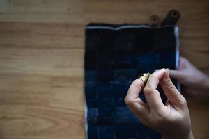 Vintage-Frau näht Stoff von Hand mit Stickerei auf Holztischhintergrund - Menschen und handgefertigtes DIY-Hausarbeitskonzept foto