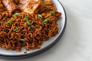 jajangmyeon oder jjajangmyeon mit odeng und omuk - koreanische Instantnudeln mit koreanischem Fischkuchen in schwarzer Bohnensauce foto