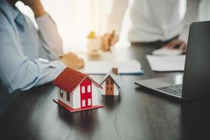 Immobilienmakler-Agent präsentiert und berät den Kunden bei der Entscheidungsfindung, unterzeichnet den Versicherungsvertrag, das Hausmodell, das Hypothekendarlehensangebot für und die Hausversicherung. foto