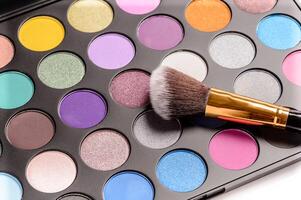 dekorative kosmetik für augenmake-up, palette mit leuchtenden farben und kosmetikpinsel foto