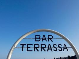 barschild, terrasse an der tür einer bar am strand foto