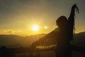 silhouette freiheit glückliche dame, die bei sonnenaufgang oder sonnenuntergang im hochlandgebiet chiang mai thailand ihre hand zum himmel hebt - menschen glückliche freiheit im naturkonzept foto