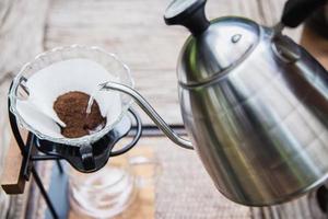 Mann, der frischen Kaffee im Vintage-Café mit grünem Naturhintergrund macht - Menschen mit frischem Kaffee im Naturkonzept foto