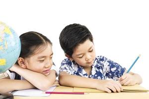 asiatische Kinder studieren den Globus auf weißem Hintergrund foto