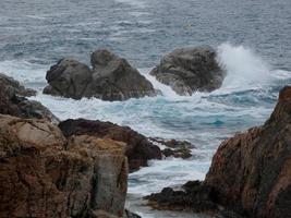 raue See, Wellen, die gegen die Felsen schlagen foto