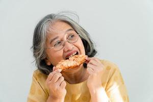 glückliche asiatische seniorinnen genießen es, kuchen zu essen foto