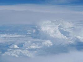 Luftaufnahme der Wolkenlandschaft durch das Flugzeugfenster gesehen foto