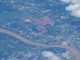 Luftaufnahme des landwirtschaftlichen Feldes und des Flusses durch das Flugzeugfenster gesehen foto