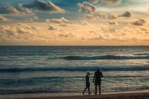 Mann und Frau am Meeresstrand schauen in die Ferne foto