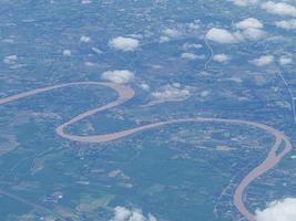 Luftaufnahme des landwirtschaftlichen Feldes und des Flusses durch das Flugzeugfenster gesehen foto